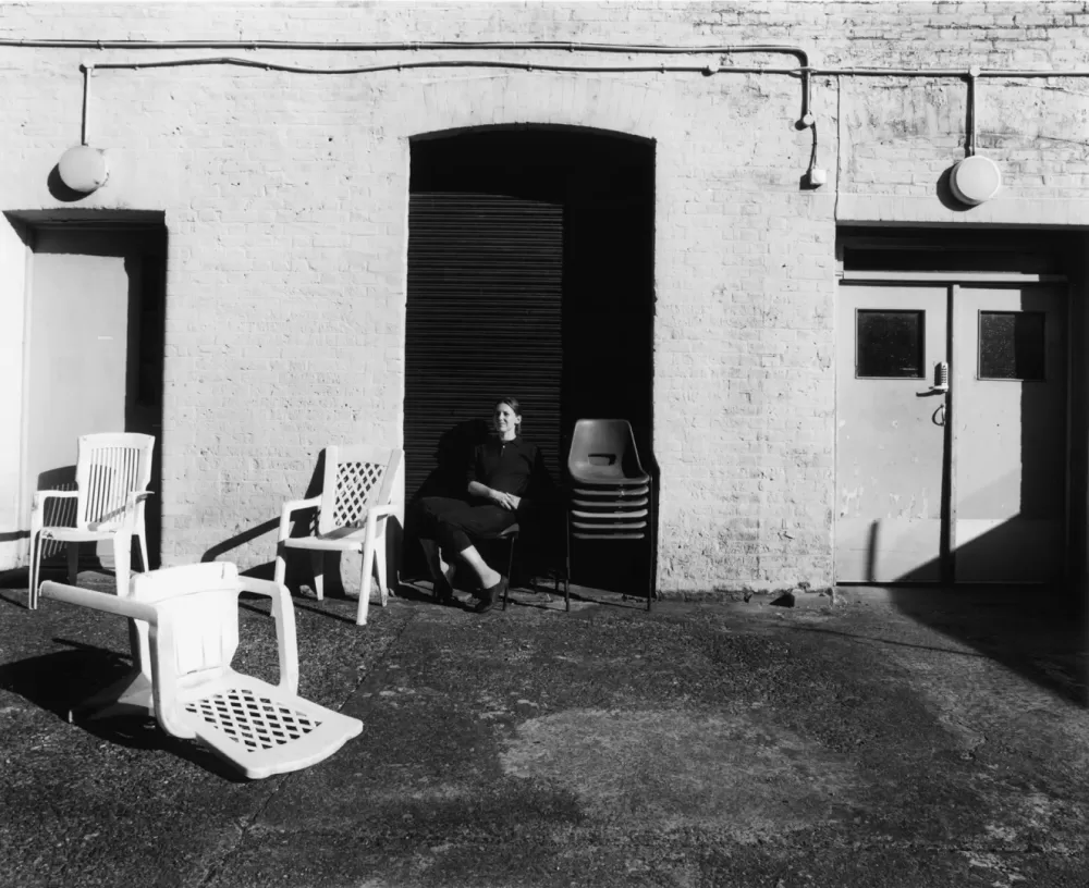 A black and white photograph of Barbara Wesołowska sat outside her east London studio