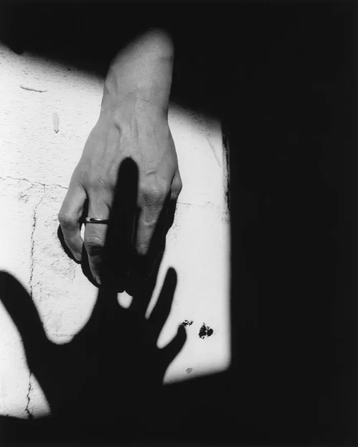 A black and white photograph of Barbara Wesołowska's hand placed against a wall