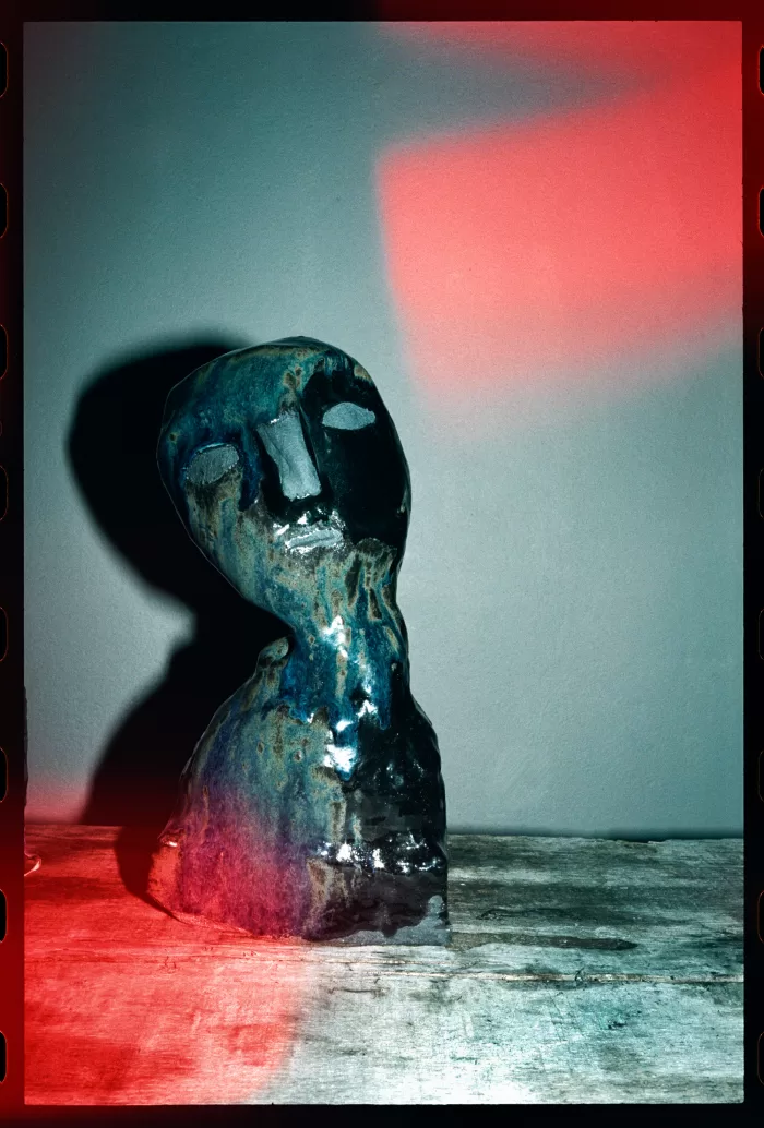 A photograph of an abstract ceramic sculpture of a head