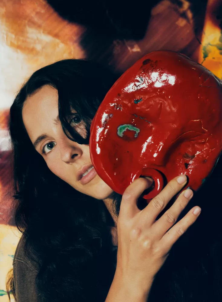 A close-up photograph of Harley Weir holding one of her ceramic sculptures