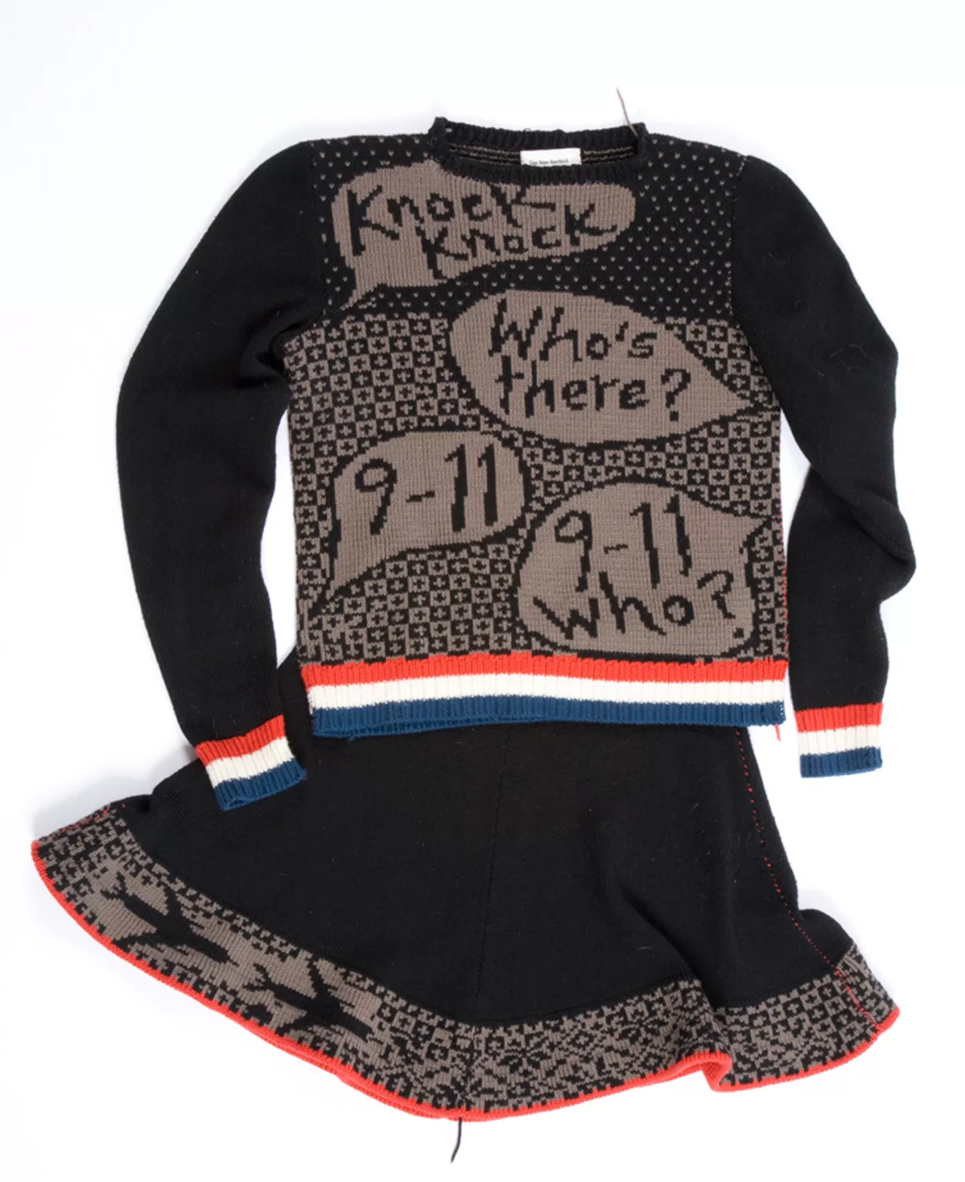 A knitted skirt and jumper set from Lisa Auerbach's 'Sweaters and Skirts' series. The text on the jumper reads 'Knock knock. Who's there? 9-11. 9-11 who?'