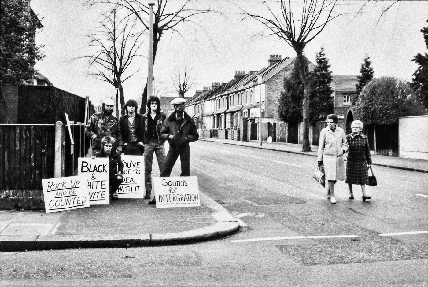 Black and white photograph of a group of protesters with signs in the street