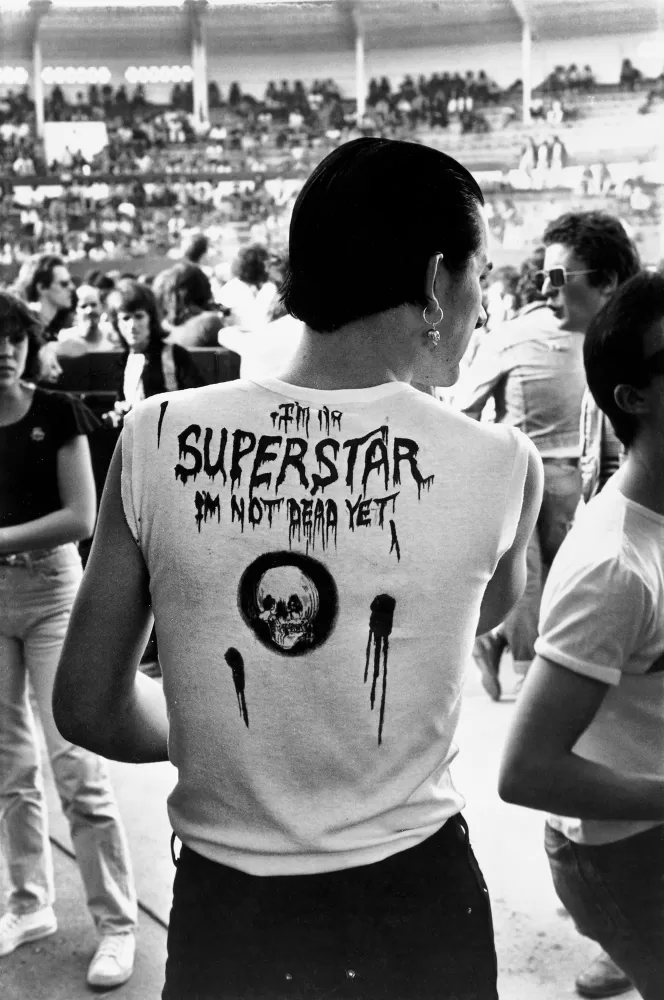 Black and white photograph of a man stood at the entrance of a concert arena