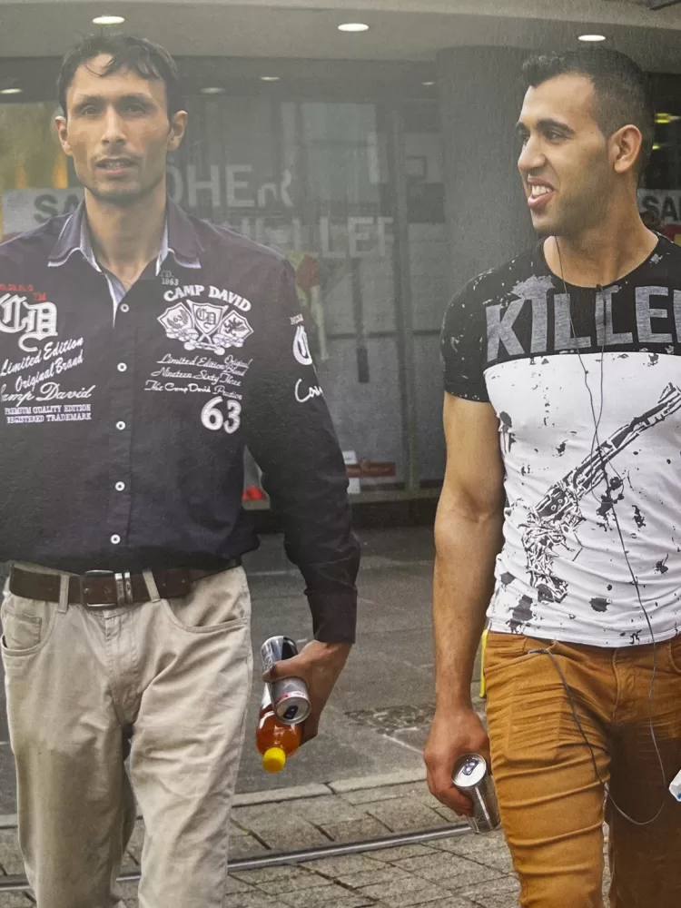 A photograph of a page from a photobook featuring a candid photograph of two people walking out of a shop