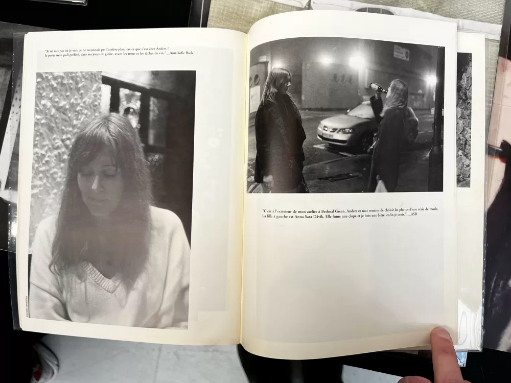 A photograph of a double-page spread from a photobook featuring a portrait of a woman and a photograph of two women on a city street