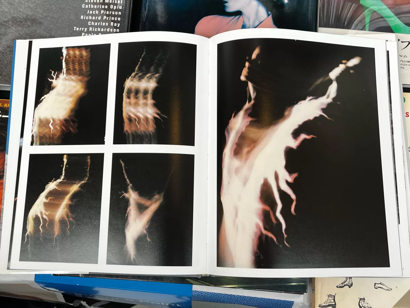 A photograph of a double-page spread from a photography book featuring long exposure shots of a woman that resembles a lighting strike