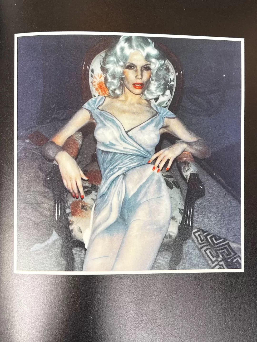 A photograph of a page from a photography book picturing a woman posing wearing body paint