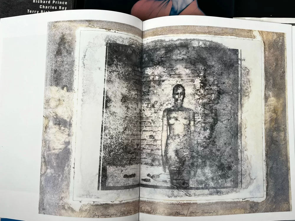 A photograph of a double-page spread from a photography book picturing a woman camouflaged with body paint