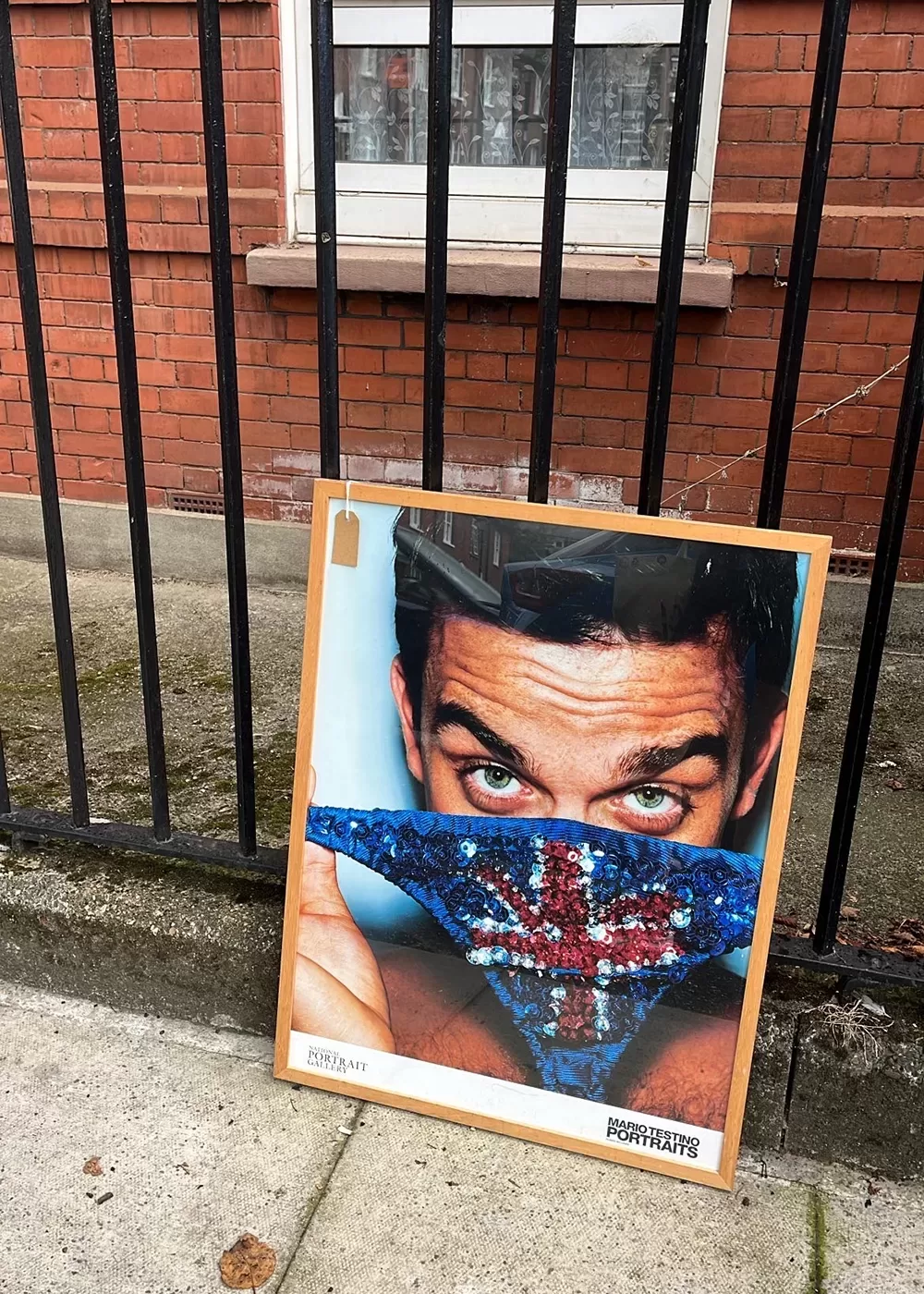 An abandoned Robbie Williams poster on the street