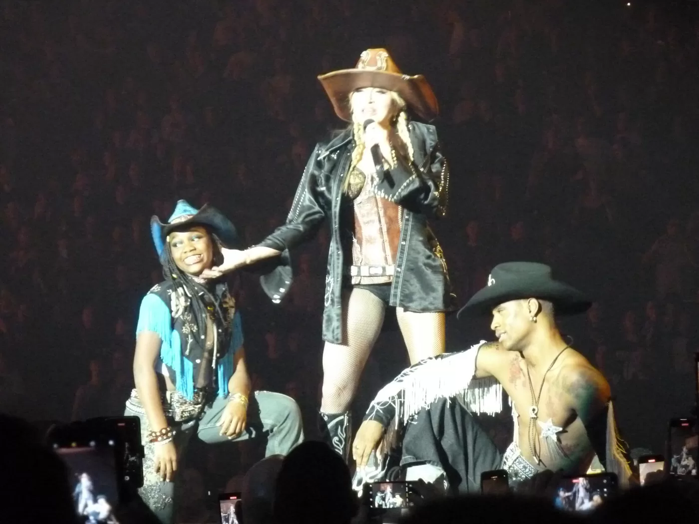 Madonna and two tour dancers dressed as cowboys on stage