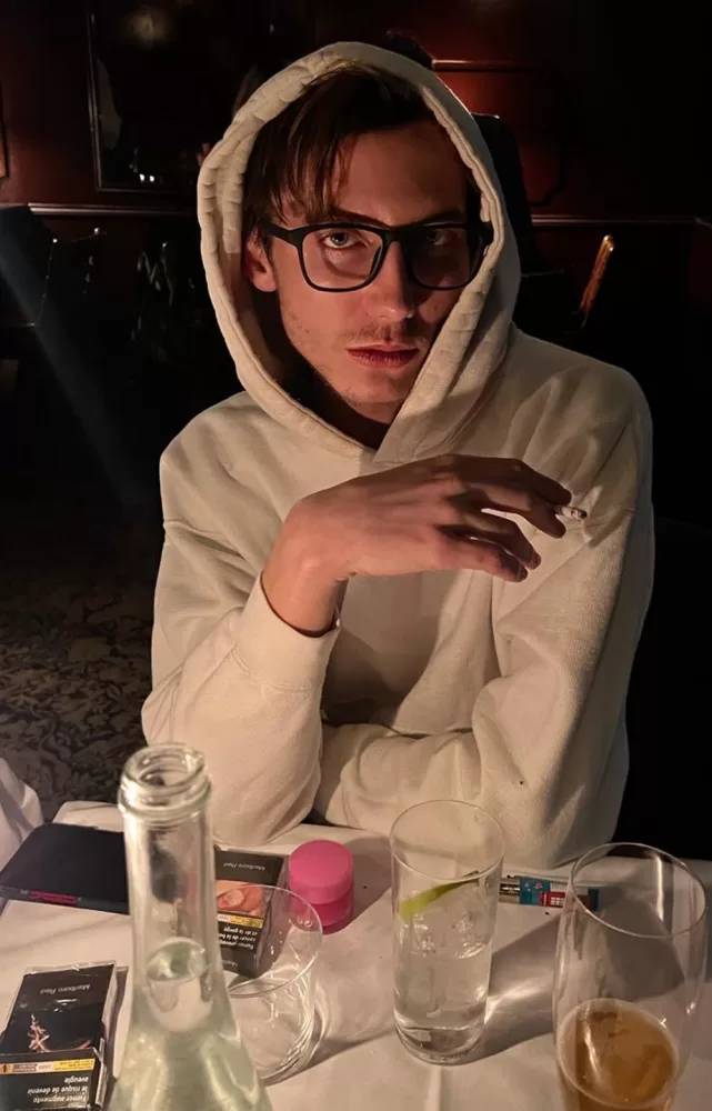 Photograph of Paul Hameline at dinner in Paris smoking a cigarette