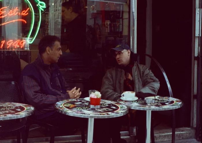 Joshua Leon and Abbas Zahedi sit outside Bar Italia, in conversation over drinks