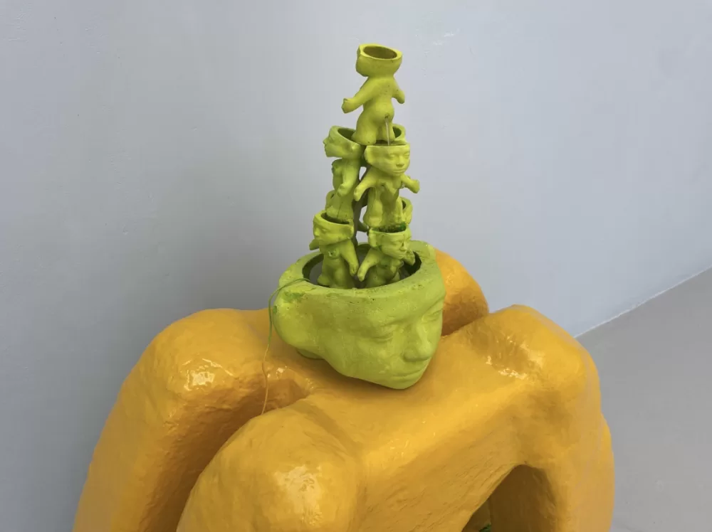 Claudia Martignetti's sculpture of a fountain made of miniature green troll sculptures